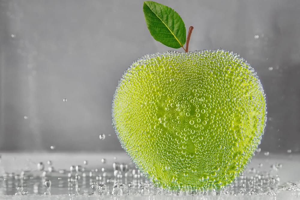 Pixxprint Grüner leckerer Apfel im Wasser, Glasbild Versandkostenfrei