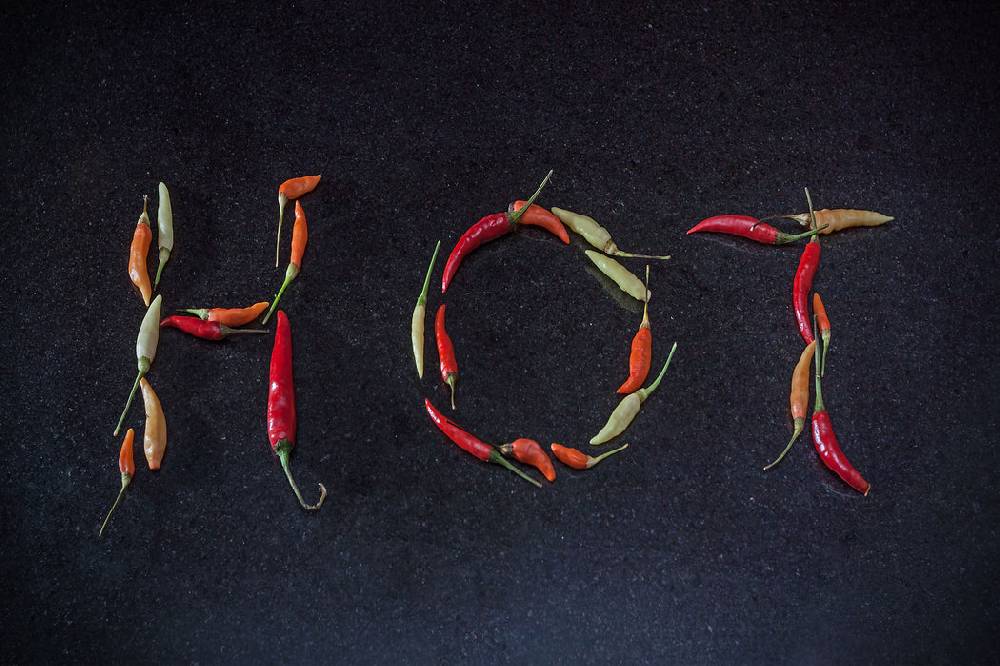 Pixxprint Chilis zu dem Wort Hot geformt, Glasbild Zeitlich begrenztes Angebot