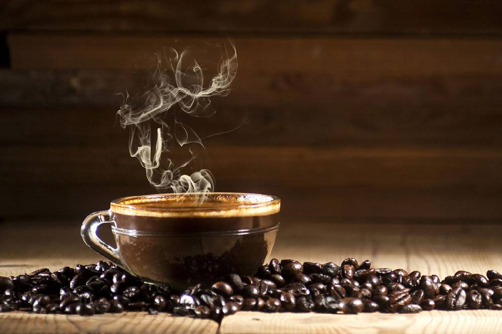 Pixxprint Kaffee zwischen Kaffeebohnen, Glasbild Neuheiten